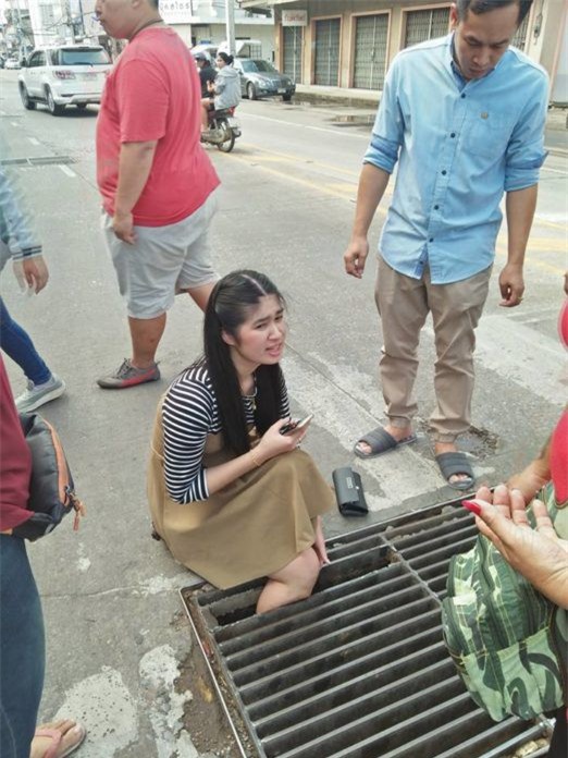 Thái Lan: Mải nghịch điện thoại, cô gái trẻ bất cẩn để lọt chân vào miệng cống ngầm, phải nhờ cứu hộ đến giải thoát - Ảnh 1.