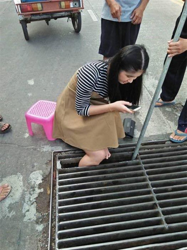 Thái Lan: Mải nghịch điện thoại, cô gái trẻ bất cẩn để lọt chân vào miệng cống ngầm, phải nhờ cứu hộ đến giải thoát - Ảnh 2.